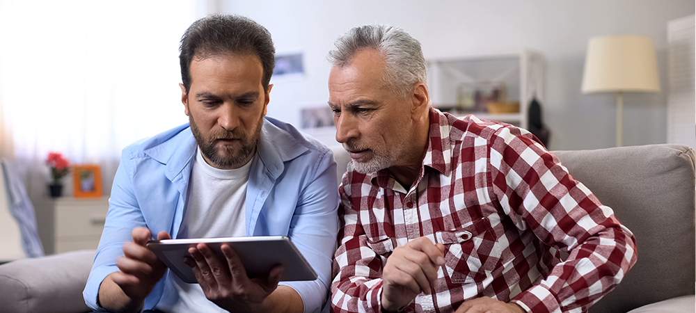 father and son looking at tablet