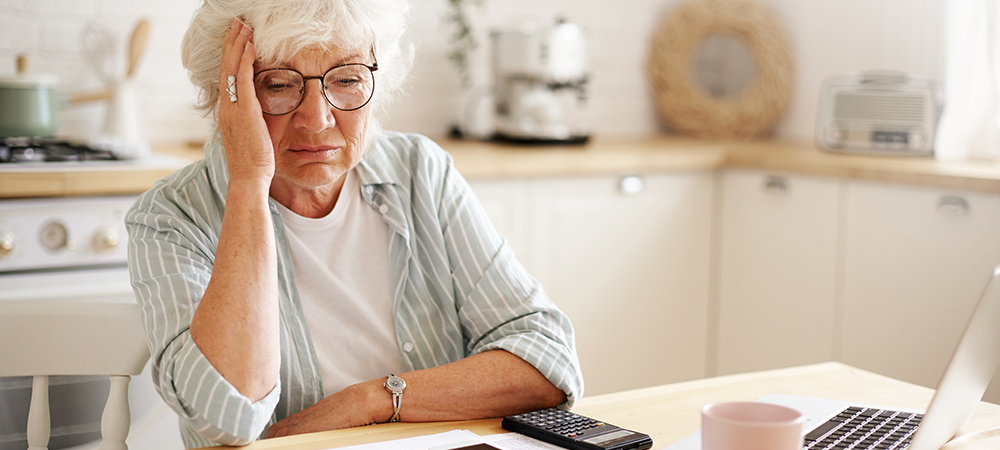 Sad Elderly woman at kitchen table